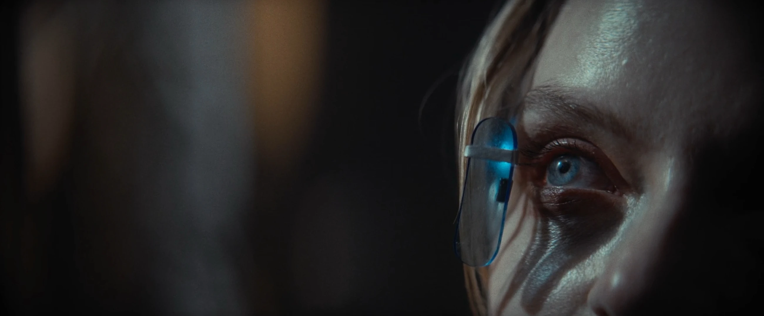 Extreme close-up of a woman wearing a transparent earpiece in Herr L.