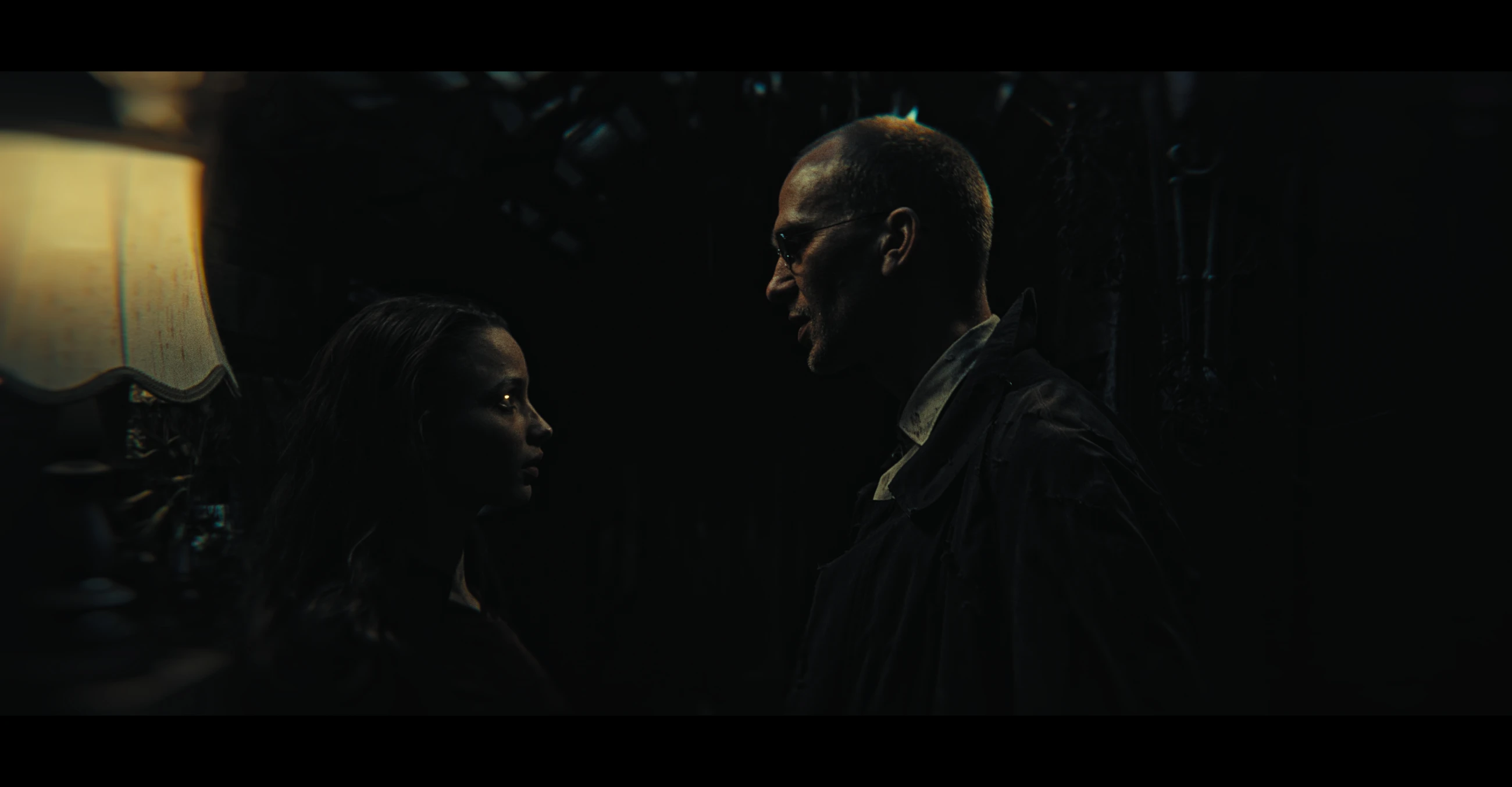A woman and a man face one another in a dark room in The Maze.