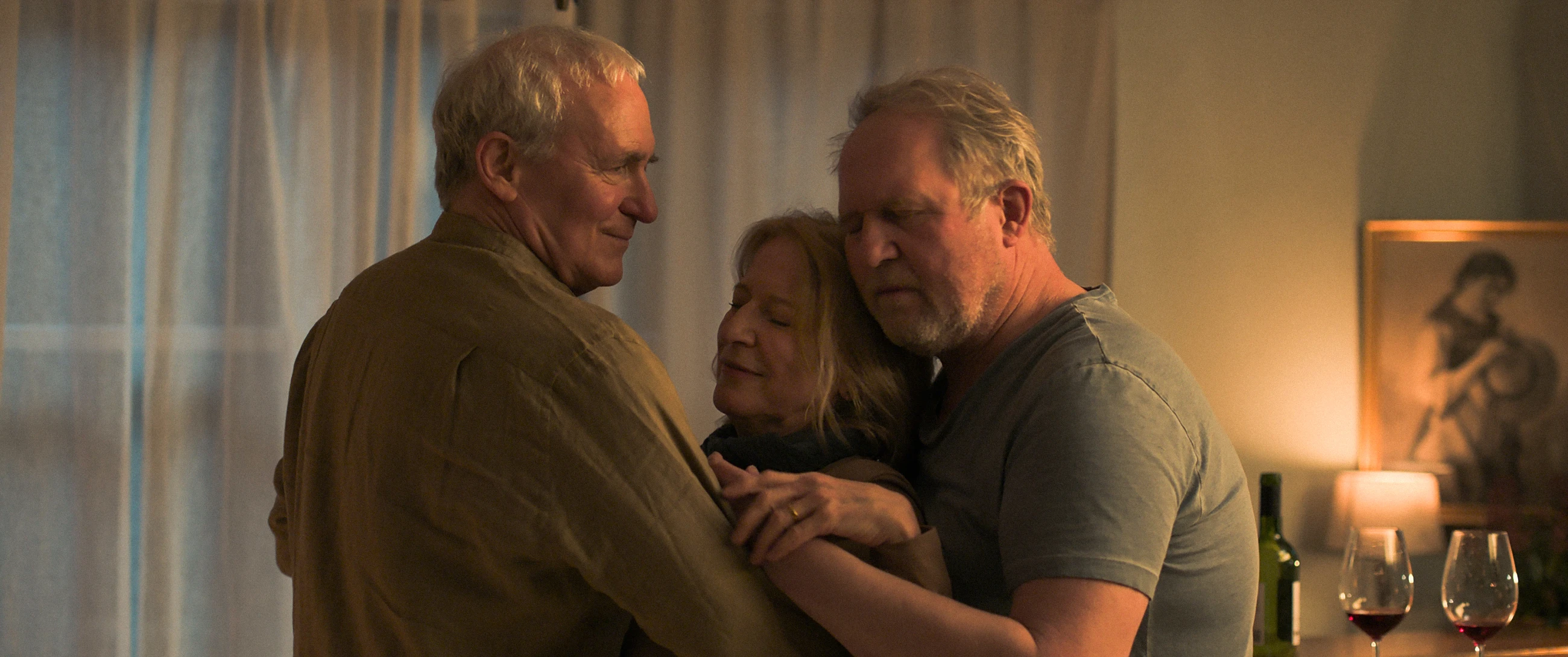 Two men comfort Hanne in a warmly lit room in Der verlorene Mann.
